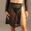 Riviera Mesh Rock Schwarz von KYNX: schwarzer Netz-Rock für Damen mit offenem Schlitz am Model, Vorderansicht