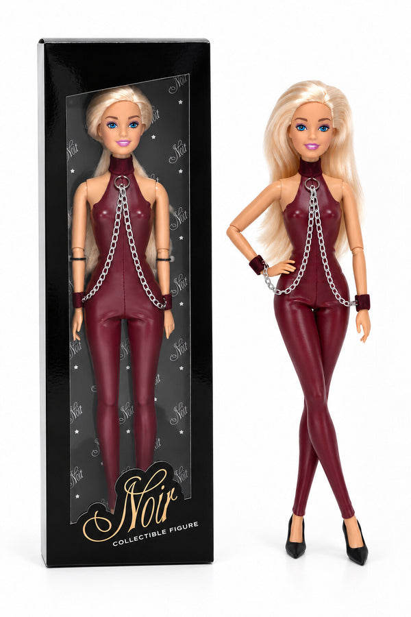 Sammlerpuppe Sweet Restraint Burgundy von Noir Handmade im burgunderfarbenen Catsuit mit Ketten und Handgelenk-Accessoires, neben ihrer Sammlerbox