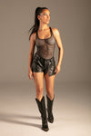 PU Leather Asymmetrische Zip-Shorts Schwarz von KYNX: Shorts mit Netz-Body und Stiefeln, Ganzkörperansicht am Model