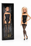 Sammlerpuppe Barely Innocent Black von Noir Handmade im schwarzen Body mit Choker und transparenten halterlosen Strümpfen, neben ihrer Sammlerbox